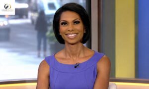 Harris Faulkner smiling in a purple dress while appearing on a television news studio set.